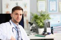 Portrait of young doctor sits in clinic office