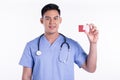 Portrait of young doctor smiling, holding credit card and standing on white background Royalty Free Stock Photo