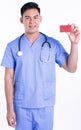 Portrait of young doctor smiling, holding credit card and standing on white background Royalty Free Stock Photo