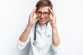 Portrait of a young doctor, on a white background, which depicts a headache, trainee in the Studio, with a stethoscope on the neck Royalty Free Stock Photo