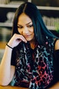 Portrait of young dreaming girl in cafe. Beautiful girl sits in coffee shop and looks,Girl smiling, hand near face