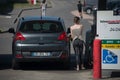 Portrait of young driver girl taking fuel for her peugeot 3008 in Intermarche gas Station