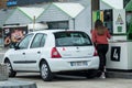 Portrait of young driver girl taking fuel in Intermarche gas Station