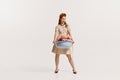 Portrait of young elegant woman doing washing, carrying bowl with clothes isolated over white background Royalty Free Stock Photo