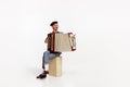 Portrait of young emotive man playing accordion, posing isolated over white studio background Royalty Free Stock Photo