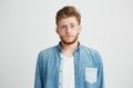 Portrait of young emotive shocked man frowning looking at camera over white background.