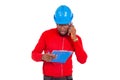 Portrait of a young engineer with notepad calling on the cellphone Royalty Free Stock Photo