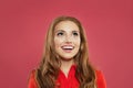 Portrait of young excited surprised woman looking up and smiling on colorful bright pink background. Girl with natural makeup Royalty Free Stock Photo