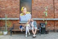 Portrait of a young family against the background red brick wall with picture.