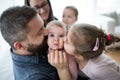 A portrait of young family with small children sitting indoors on a sofa, having fun.