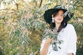 Portrait of young fashionable woman with modern earrings posing in  green olive branches in soft evening light, stylish boho girl Royalty Free Stock Photo