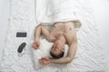 Portrait of young fast-sleeping man, top view. Sound sleep. Guy sleeps on white cotton bed linen