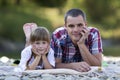 Portrait of young father and cute blond girl laying on pebbled r Royalty Free Stock Photo