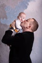 Portrait of a young father kissing his baby son on the cheek Royalty Free Stock Photo