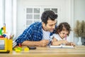 Portrait of young father teaching his cute little daughters\' study. Excited smiling small child girl enjoying learning with Royalty Free Stock Photo