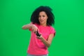 Portrait of young female African American playing a video game using a wireless controller. Black woman with curly hair Royalty Free Stock Photo