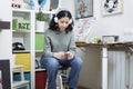 Portrait of young female art student using her mobile phone while in her studio Royalty Free Stock Photo