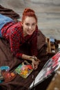 Portrait of a young female artist painting. Smiling girl with a palette in her hands and looking at the camera Royalty Free Stock Photo