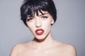 Portrait of young female with black bob hairstyle, red lips. Brunette girl with shiny glossy short hair isolated on