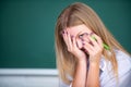 Portrait of young female college shame embarrassed student classroom on class with blackboard background. Royalty Free Stock Photo