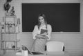 Portrait of young female college student studying in classroom on class with blackboard background. Royalty Free Stock Photo