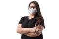 Portrait of a young female doctor in a black uniform and a mask holding a stethoscope, isolated on white background Royalty Free Stock Photo