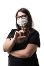 Portrait of a young female doctor in black uniform wearing a mask, holding a retro metal syringe, isolated on white background Royalty Free Stock Photo