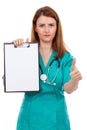 Portrait of a young female doctor holding a clipboard and showing thumb-up