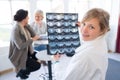 portrait young female doctor holding sheet xrays