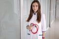 Portrait young female doctor holding a stethoscope in hands. Bright clinic Royalty Free Stock Photo