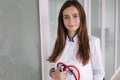 Portrait young female doctor holding a stethoscope in hands. Bright clinic Royalty Free Stock Photo