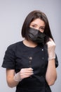 Portrait of a young female doctor in a medical mask is taken off and put on. Medical face mask professional breathing Royalty Free Stock Photo