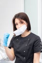 Portrait of a young female doctor in a medical mask is taken off and put on. Medical face mask professional breathing Royalty Free Stock Photo