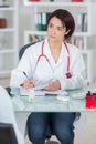 Portrait young female doctor sitting at desk in hospital Royalty Free Stock Photo