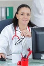 Portrait young female doctor sitting at desk in hospital Royalty Free Stock Photo
