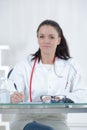 Portrait young female doctor sitting at desk in hospital Royalty Free Stock Photo