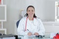 Portrait young female doctor sitting at desk in hospital Royalty Free Stock Photo