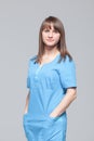 Portrait of young female doctor standing in blue uniform Royalty Free Stock Photo