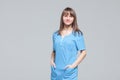 Portrait of young female doctor standing in blue uniform Royalty Free Stock Photo