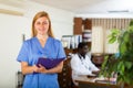 Portrait of a young female doctor standing in a office with a folder in her hands Royalty Free Stock Photo