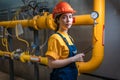 Portrait of young female engineer in a uniform and a protective helmet, holding a digital tablet in her hands and conducting an Royalty Free Stock Photo