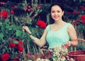 Portrait of young female holding a basket near roses in outdoor Royalty Free Stock Photo