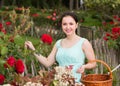 Portrait of young female holding a basket near roses in outdoors Royalty Free Stock Photo