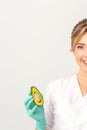 Portrait of young female nutritionist doctor with beautiful smile posing at camera holds half avocado on white Royalty Free Stock Photo