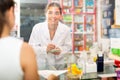Portrait of a young female pharmacist in a pharmacy taking an order for a medicine Royalty Free Stock Photo