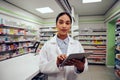 Portrait of young african american female standing near counter in pharmacy using digital tablet Royalty Free Stock Photo
