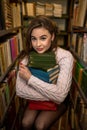 portrait of young female student or teacher near books in the library Royalty Free Stock Photo