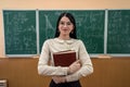 portrait of young female teacher against blackboard with math formula in classroom Royalty Free Stock Photo