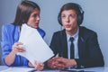 Portrait of young female team leader aggressive attacks male employee working in office. Horizontal image