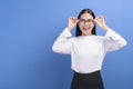 Portrait of young female wearing glasses over blue background studio  healthcare concept Royalty Free Stock Photo